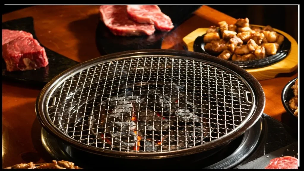 Korean BBQ grill with charcoal fire, fresh raw beef, and marinated meat ready for grilling
